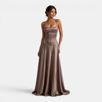 Woman wearing a long, elegant brown dress on a white background