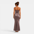 Woman wearing a strapless, floor-length dress on a white background