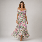 A woman modeling an off-the-shoulder maxi dress with a watercolor floral pattern in pink, green, and purple on a light gray background.
