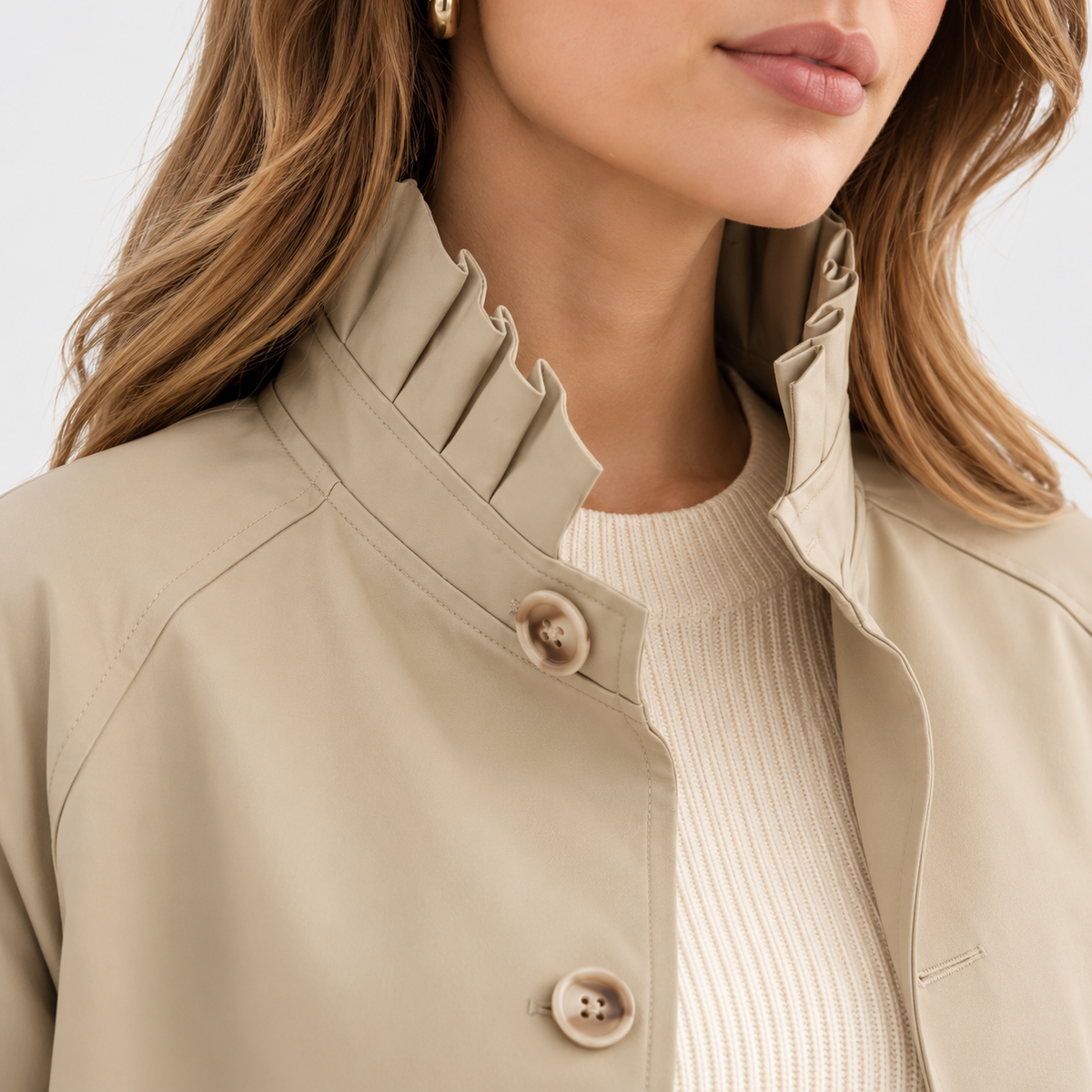 Close-up of beige jacket collar and button details with checked cuff accents