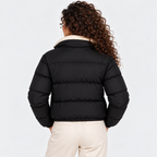 Back view of a woman wearing a black quilted puffer jacket with shearling collar