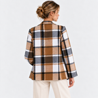 Back view of a woman wearing a brown and black plaid blazer jacket