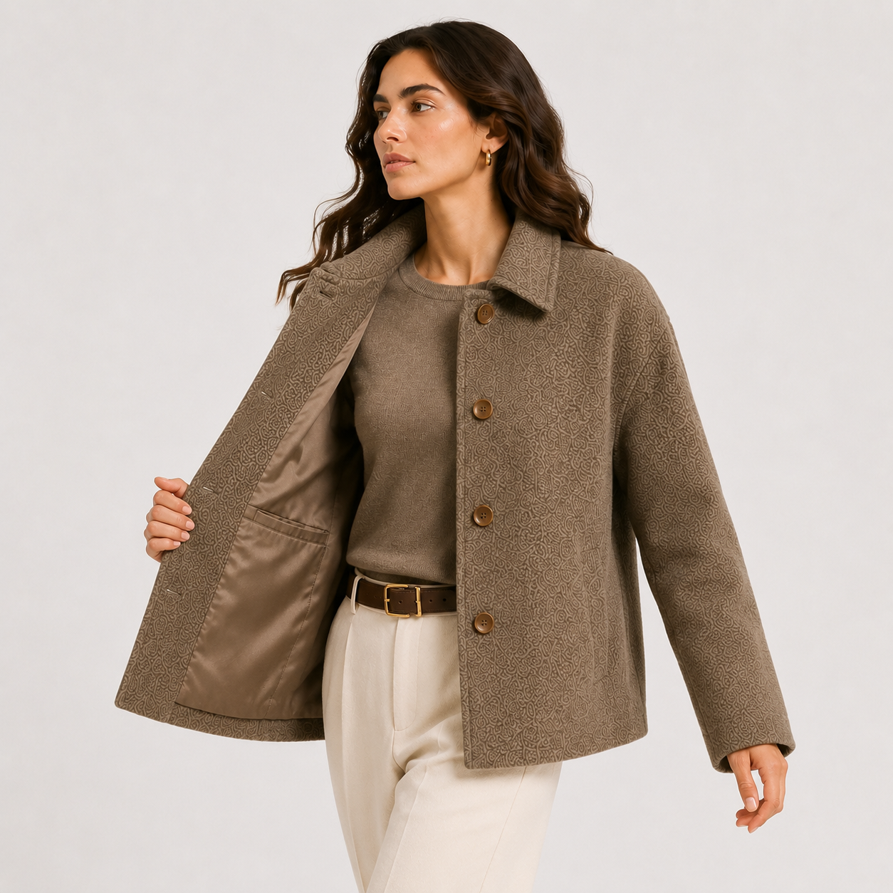 A woman models a taupe brown textured wool-blend coat with brown buttons, worn open over a matching taupe top and cream trousers, against a light gray studio background.