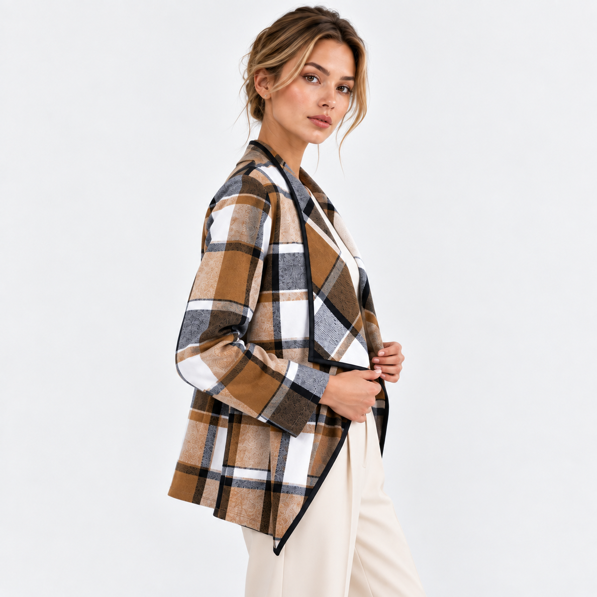 Side angle of a woman wearing a brown and black plaid blazer with white pants