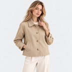 Woman styling a beige button-front jacket with white pants