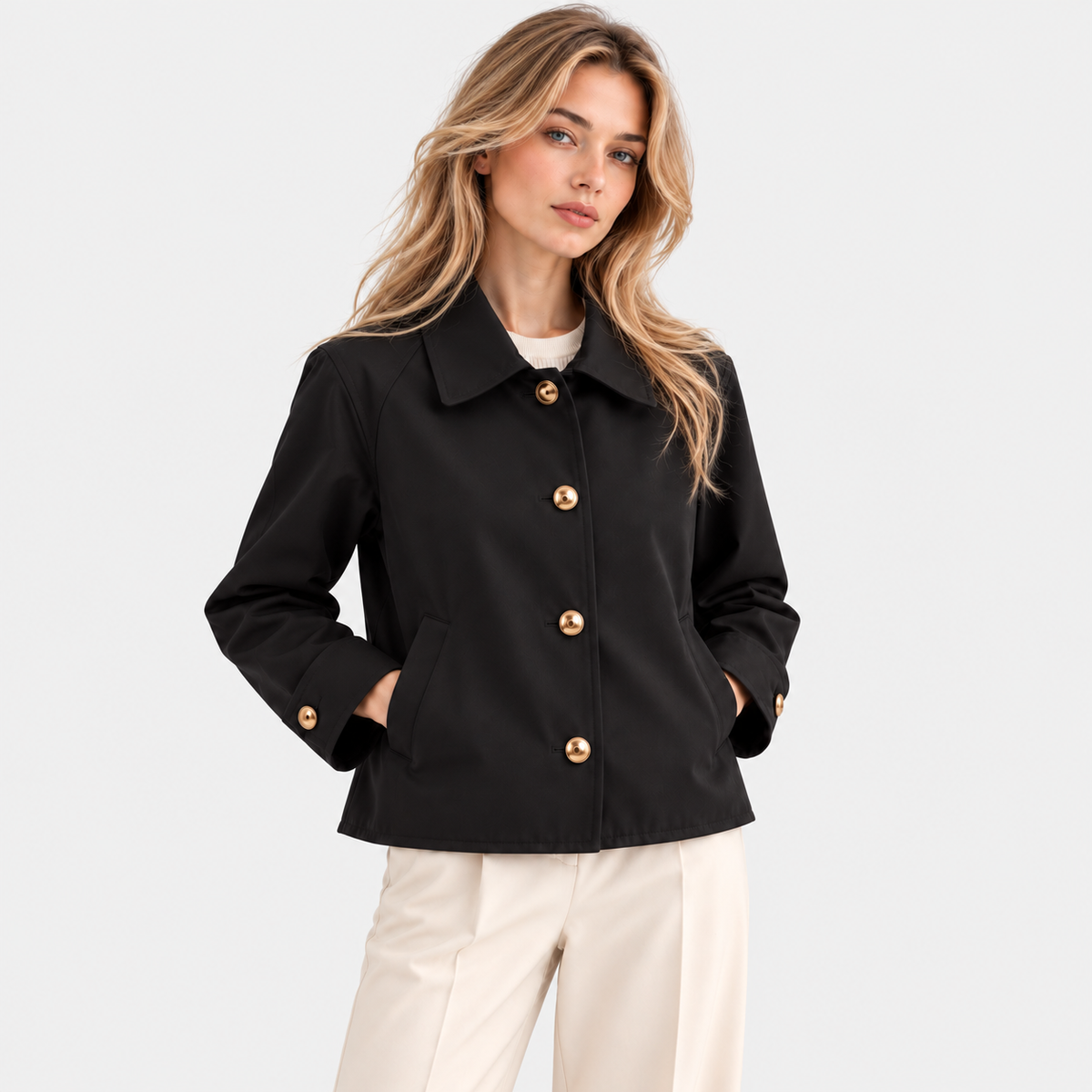 Black button-front jacket styled with white pants on a woman
