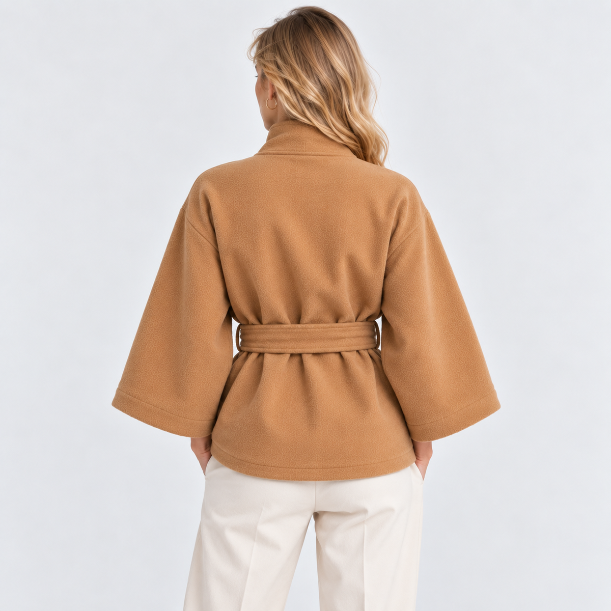 Back view of a camel brown cape coat with wide sleeves and matching waist belt