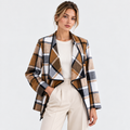 Women's plaid blazer jacket with brown and black check pattern over a white top and pants