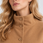 Close-up of women's camel brown cape coat with stand collar and button closure