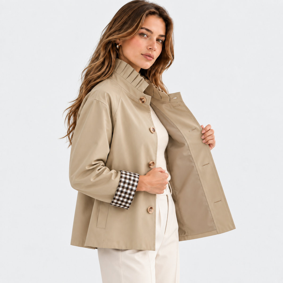 Side view of a woman wearing a beige button-front jacket with checked cuffs and white pants