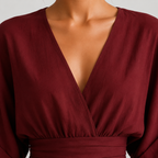 Close-up of a woman wearing a deep burgundy wrap-style top with a V-neckline and gathered waist detail.