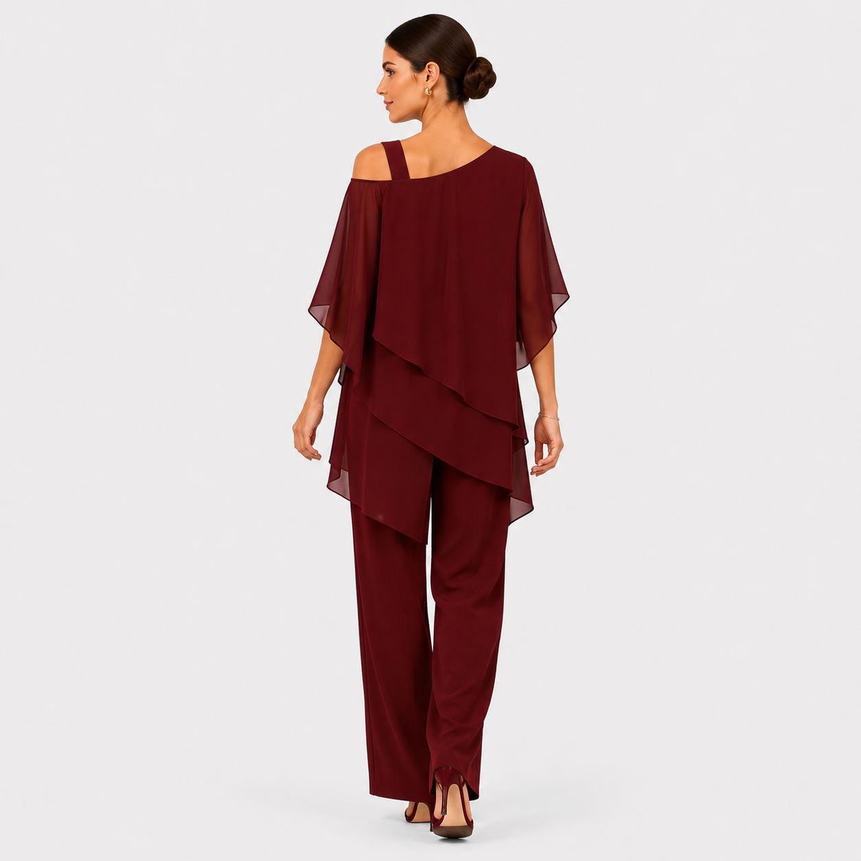 A woman modeling a burgundy two-piece outfit consisting of an off-the-shoulder draped top and matching wide-leg pants, shown from the back against a light gray studio background.