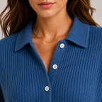 Close-up of a woman wearing a blue ribbed knit collared button-front top with white buttons and delicate gold necklaces.