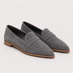 A pair of gray suede penny loafers with pointed toes and low brown block heels, shown on a light gray background.