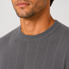 Close-up of a man wearing a dark gray ribbed crewneck sweater, showing the texture of the knit fabric and the collar.