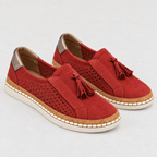 A pair of red suede slip-on espadrille-style shoes with tassel details, perforated side panels, and beige soles, shown on a light gray background.