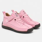 A pair of pink high-top sneakers with black soles and matching pink laces, displayed on a light gray background.