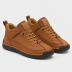 A pair of mid-height casual sneakers in a warm brown leather-like material, featuring matching brown laces, a black textured sole, and a small 'SPORT' label on the tongue, set against a light gray background.