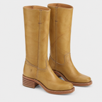 A pair of tall tan leather boots with stacked wooden heels, shown from a three-quarters angle on a light gray background.