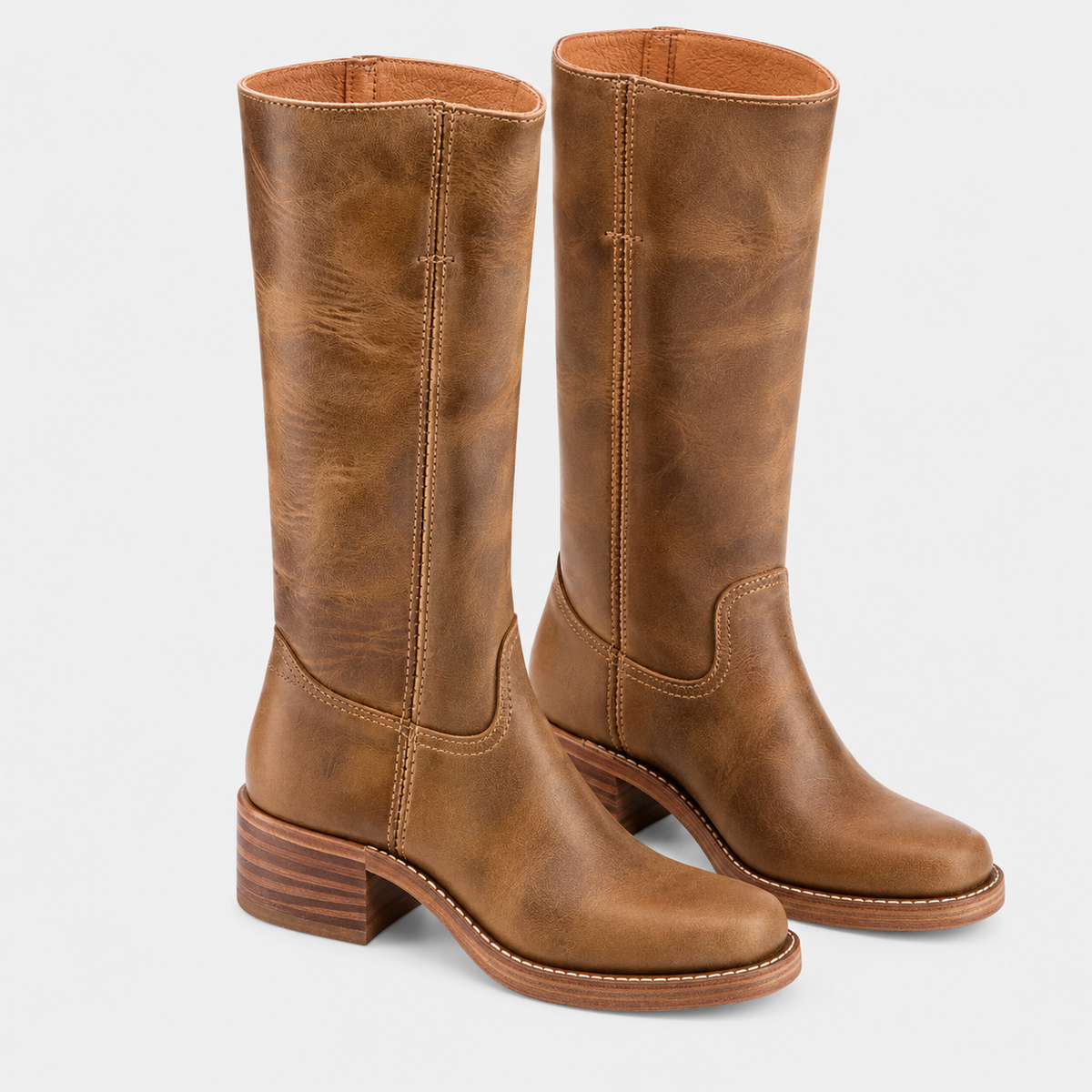 A pair of tall brown leather boots with a distressed finish, stacked block heels, and whipstitch detailing, shown against a light gray background.