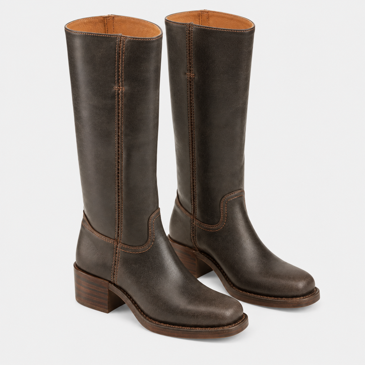 A pair of dark brown leather knee-high boots with a low block heel and western-style stitching, shown against a light gray background.