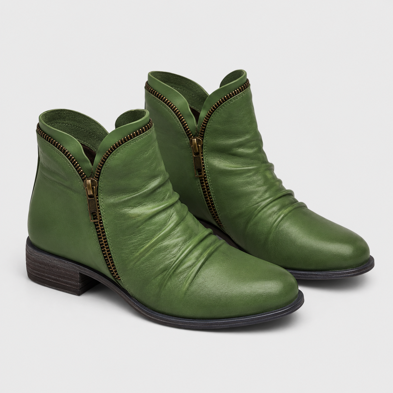 A pair of olive green leather ankle boots with a side zipper, dark brown stacked block heel, and gold-tone zipper pull, shown on a light gray background.