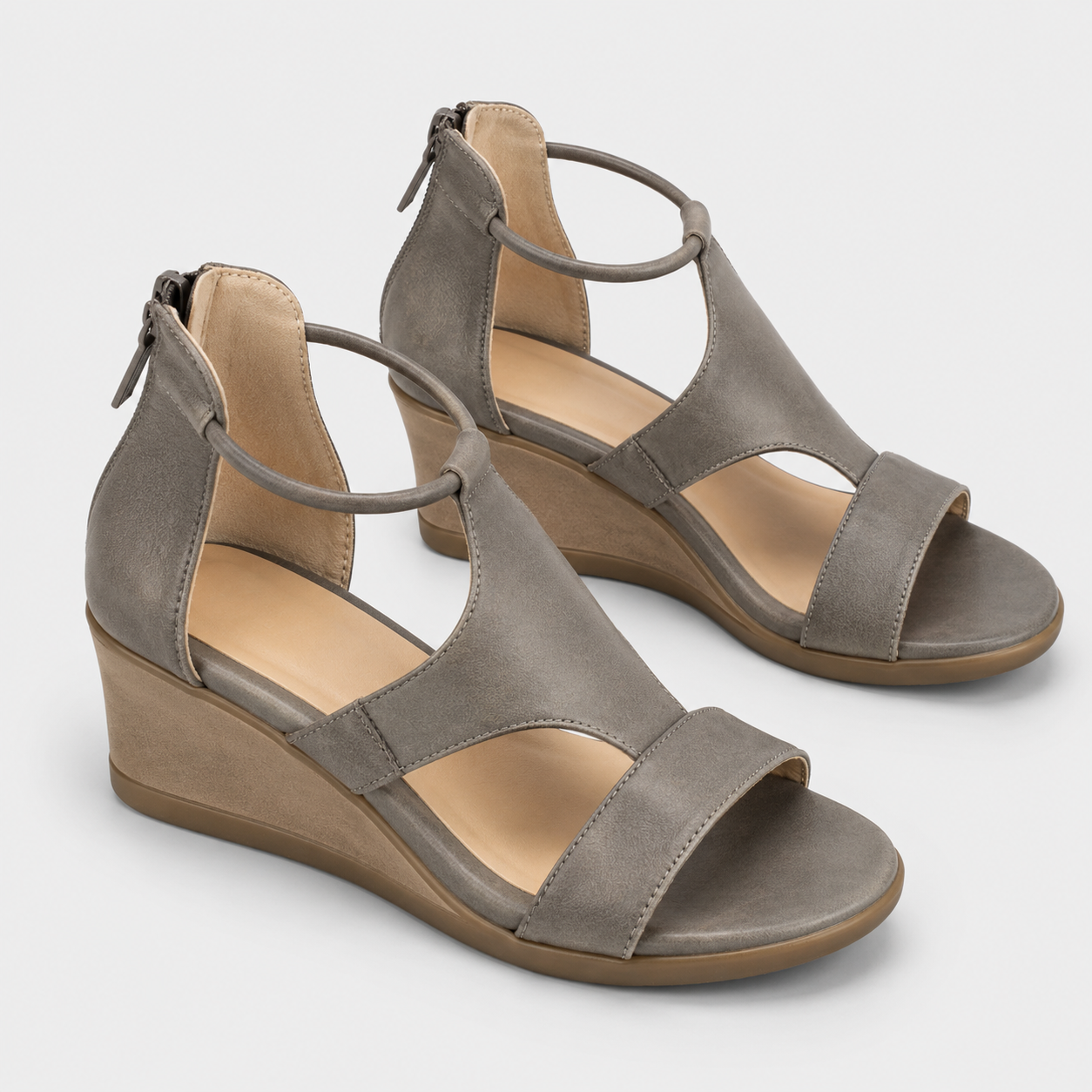 A pair of women's wedge sandals in taupe gray faux suede with a tan insole and brown wedge sole, shown on a light gray background.