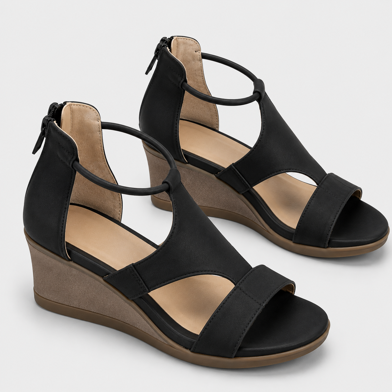 A pair of women's black wedge sandals with cutout straps, ankle ties, and side zippers, shown on a light gray background.