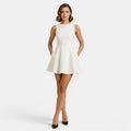 Woman wearing a white dress on a plain background
