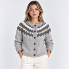 A woman modeling a light gray knit cardigan with a dark gray and white Fair Isle pattern across the chest and waist, featuring brown buttons, paired with cream trousers against a light gray studio background.