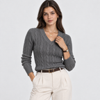 A woman modeling a dark gray cable-knit V-neck sweater paired with cream-colored trousers and a brown belt, shot against a light gray studio background.