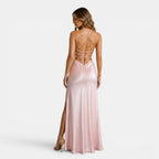 Woman wearing a pink evening gown with a backless design on a white background