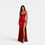 Woman wearing a red evening gown with a high slit on a white background