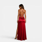 Woman wearing a red evening gown with a backless design on a white background
