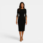 Woman wearing a black dress with studded sleeves on a white background