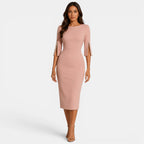 Woman wearing a pink dress with cut-out sleeves on a white background