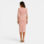 Woman wearing a pink dress with cut-out sleeves on a white background