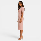 Woman wearing a pink dress with ruffled sleeves on a white background