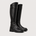 Black knee-high boots with ruched design on a light gray background