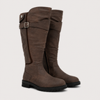 A pair of knee-high brown suede boots with a buckle strap detail on the side, shown against a light gray background.