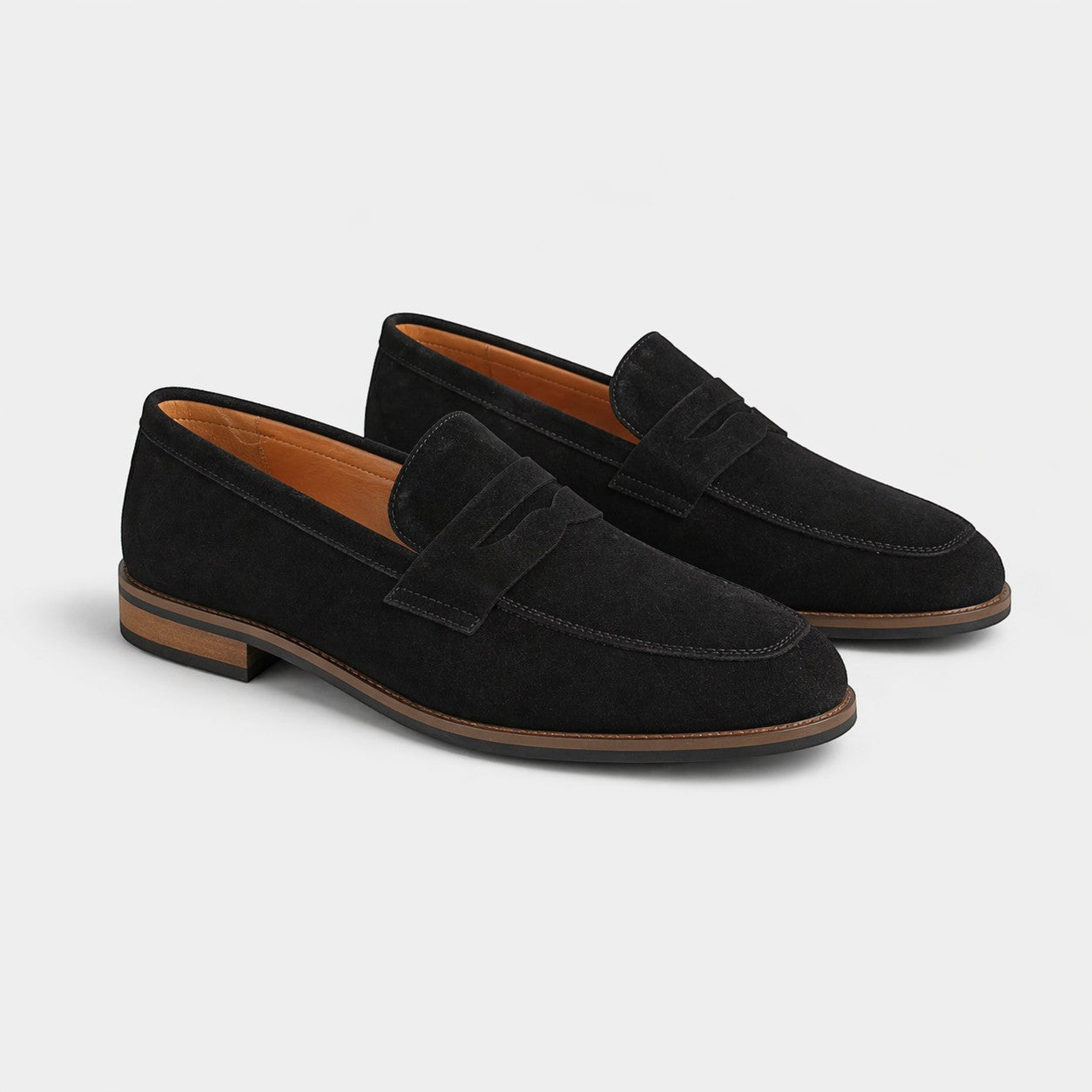 Pair of black suede loafers on a light gray background