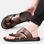 Brown sandals being worn on a light gray background