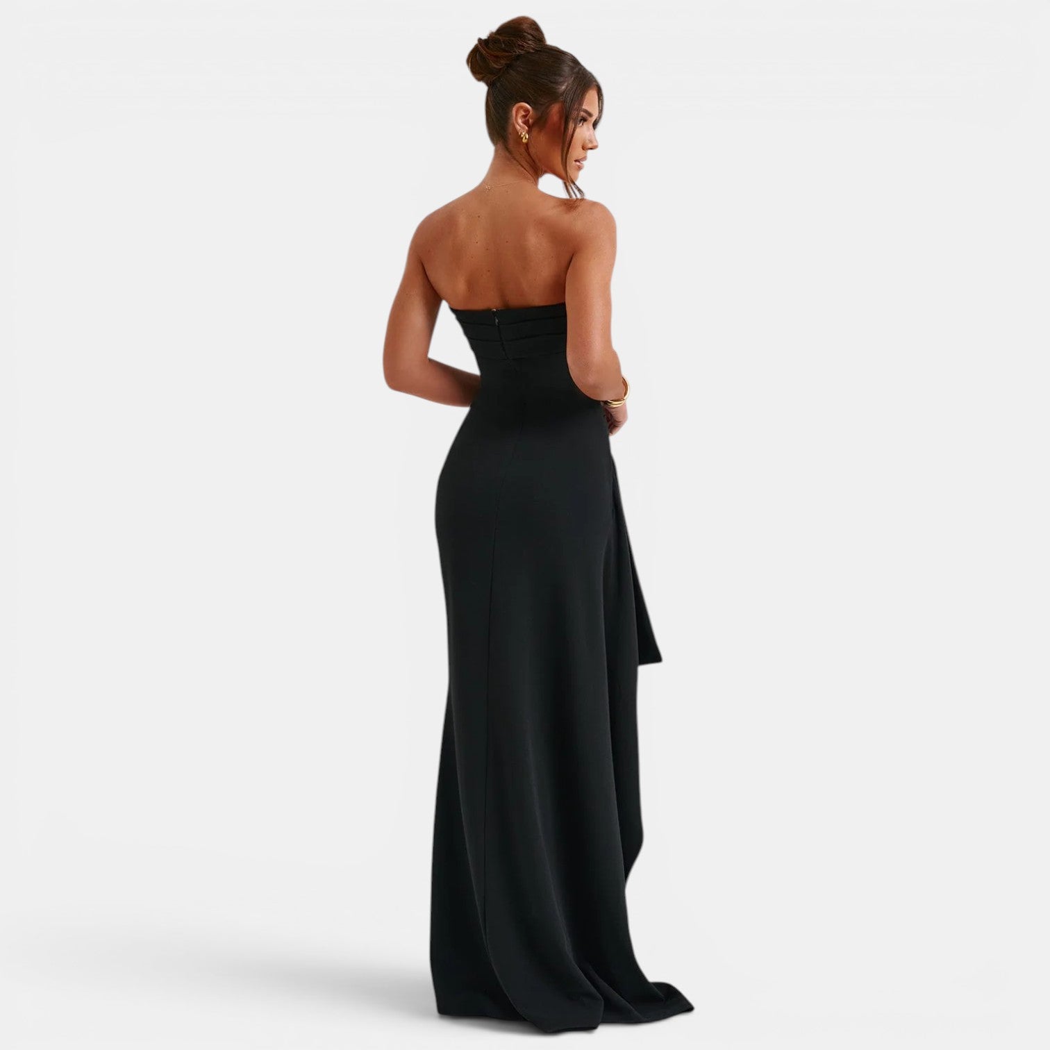 Woman wearing a black strapless gown on a white background