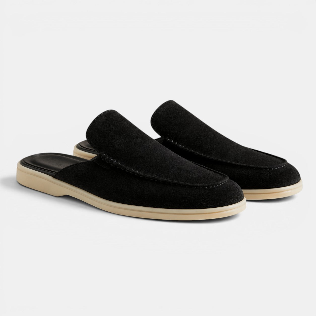 Black loafers with beige soles on a white background