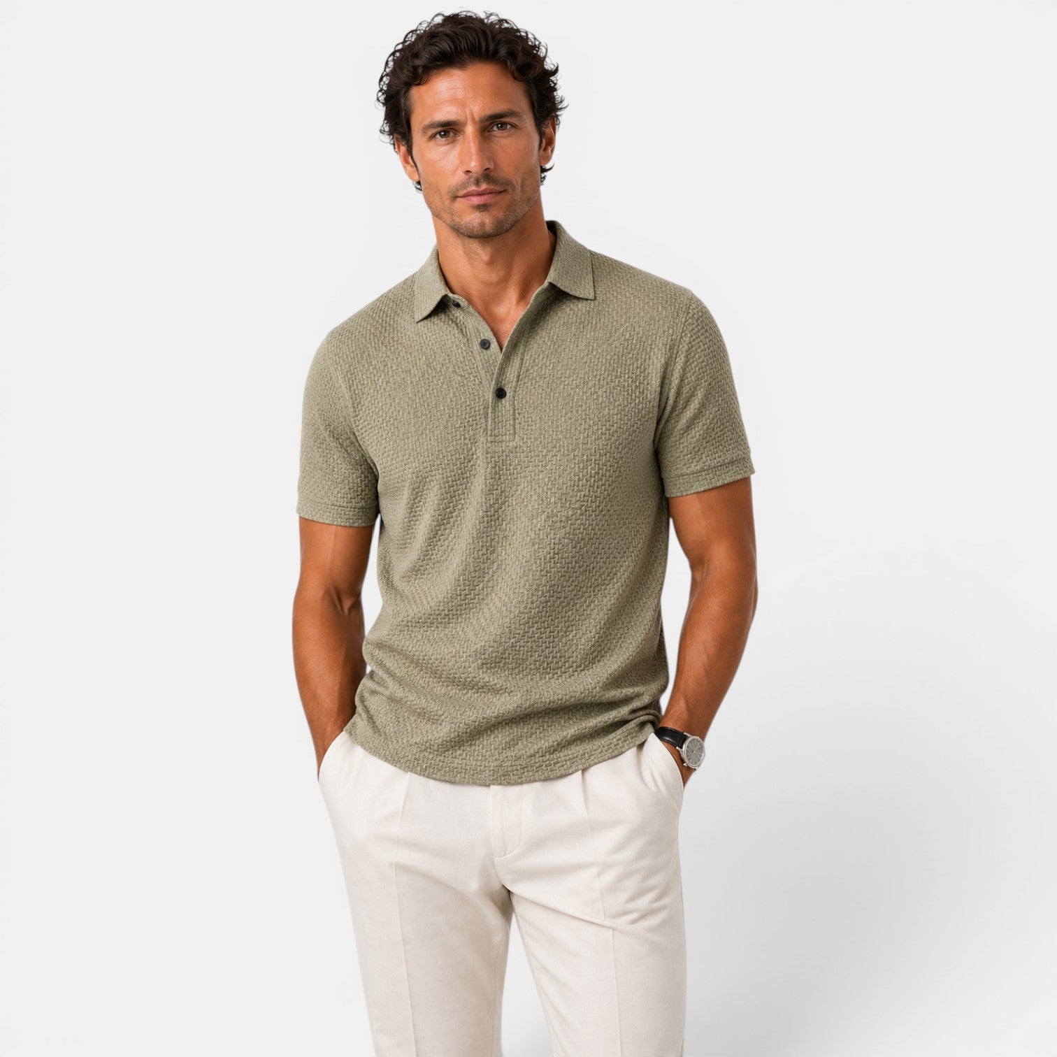 Man wearing a green patterned polo shirt and white pants on a light gray background
