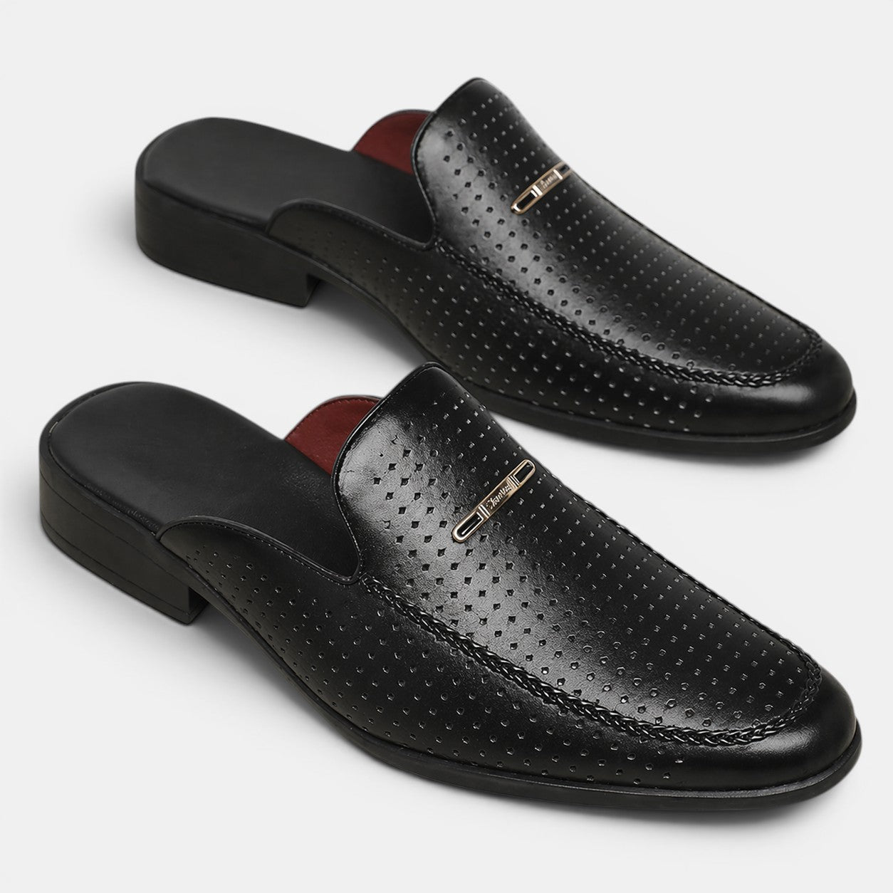 Black perforated loafers with brown insole on a white background