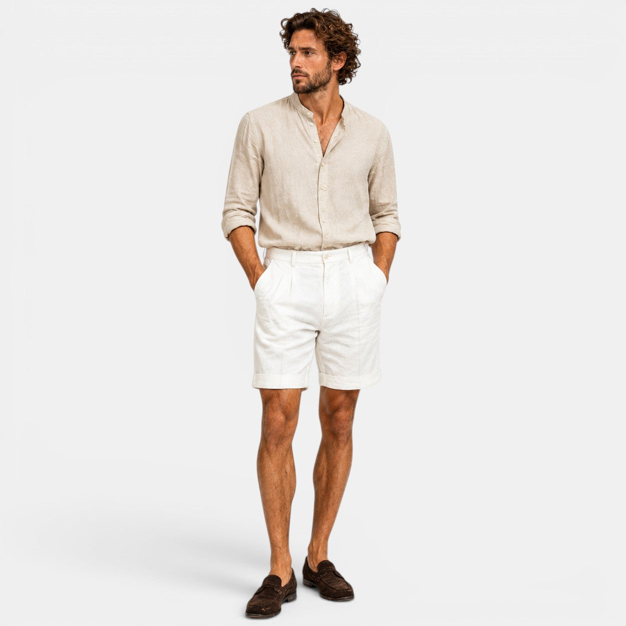 Man wearing a beige shirt and white shorts on a white background