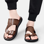 Brown sandals worn with black pants on a light gray background