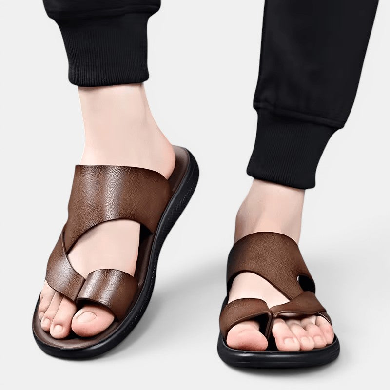 Brown sandals worn with black pants on a light gray background
