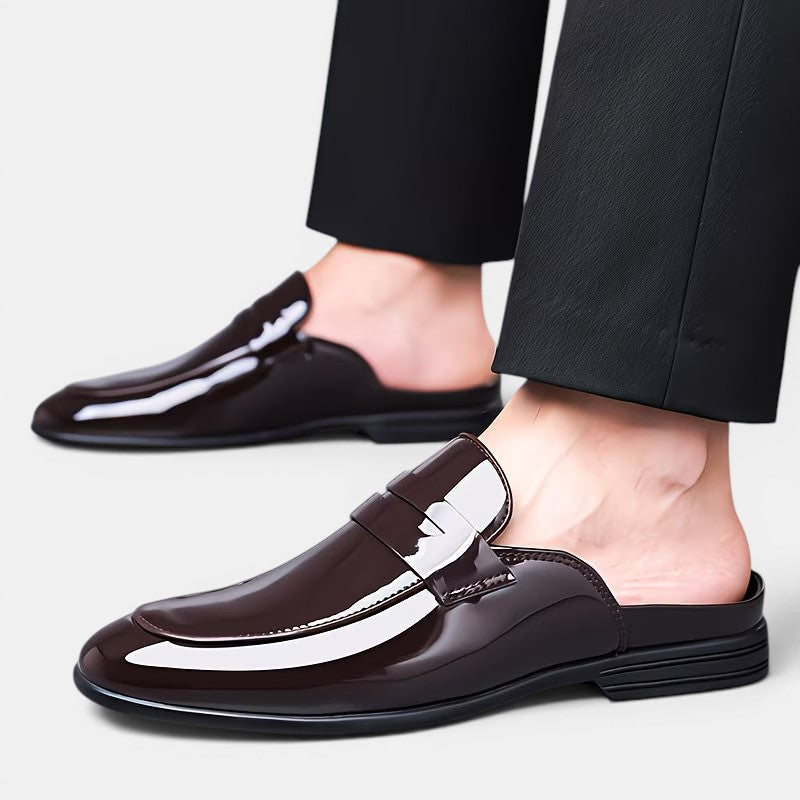 Brown loafers worn with black pants on a light gray background